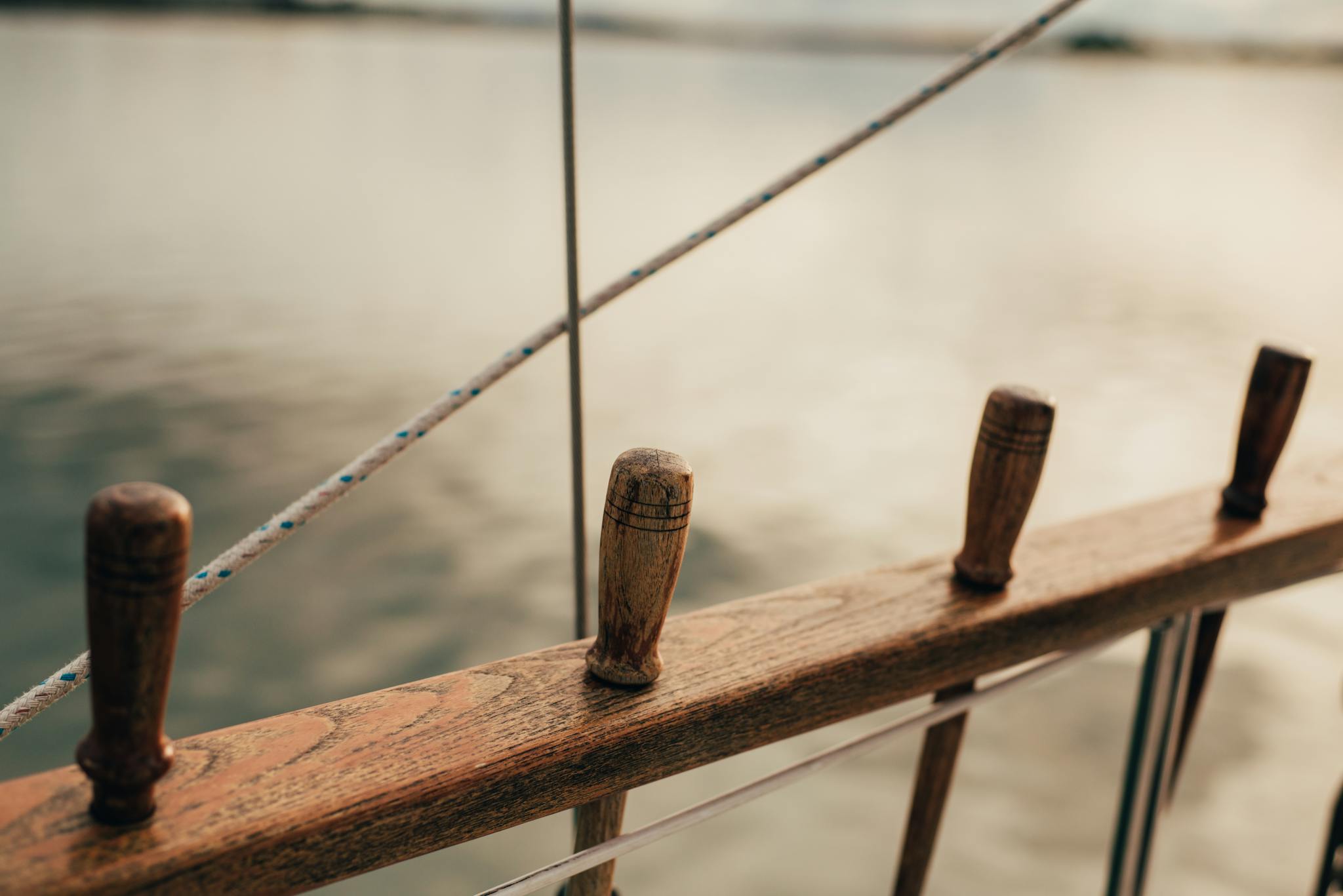 Detailed close-up of a boat's wooden railing and handles on a calm lake in Thunder Bay.